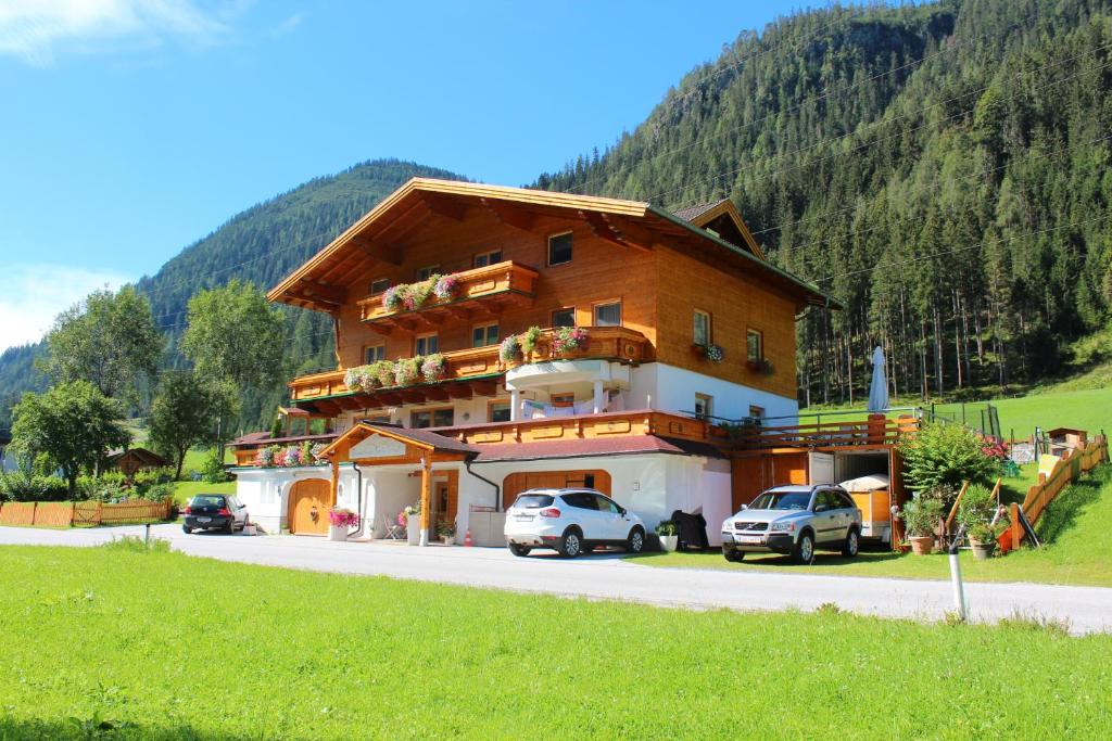 un grand bâtiment avec des voitures garées devant lui dans l'établissement Ferienwohnung Schnell, à Flachau