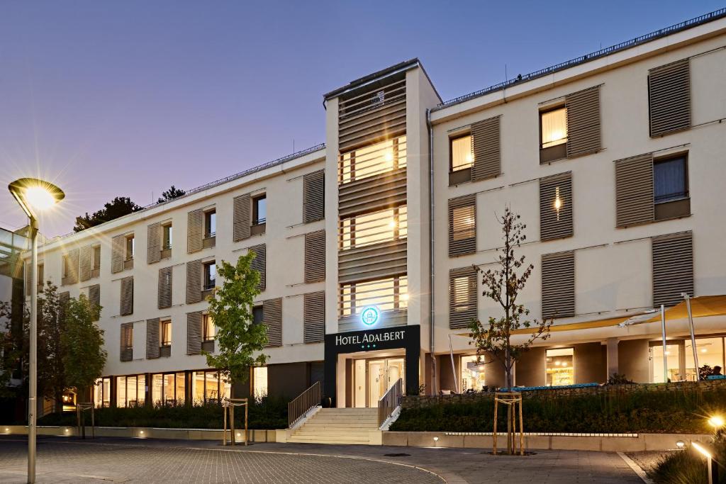 un gran edificio blanco con un cartel. en Hotel Adalbert Szent Tamás ház en Esztergom