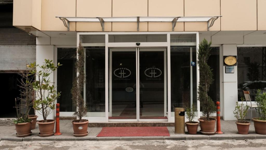 een toegang tot een gebouw met potplanten ervoor bij Gaziantep Garni Hotel in Gaziantep