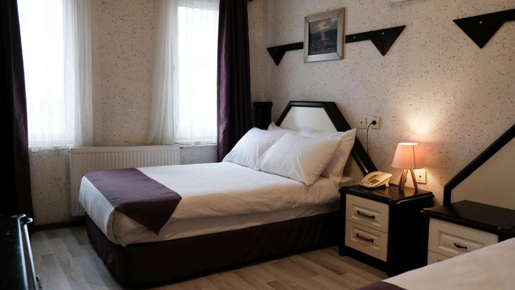 Un pat sau paturi într-o cameră la Kucuk Velic Hotel