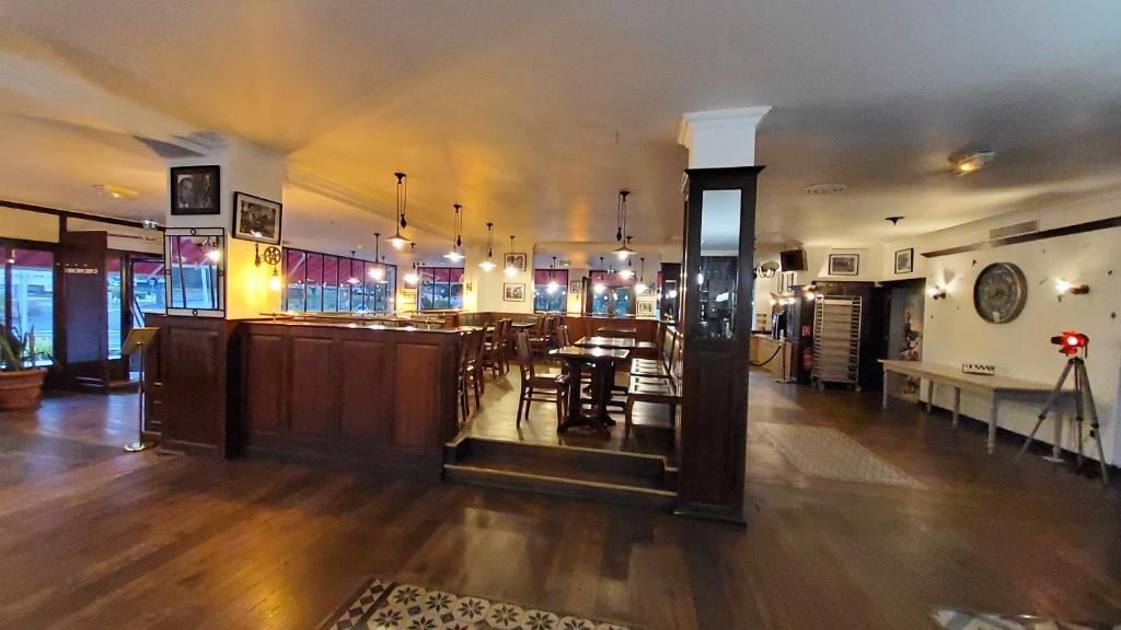 a restaurant with a bar with tables and chairs at Hôtel Le Sully La Roche Sur Yon in La Roche-sur-Yon