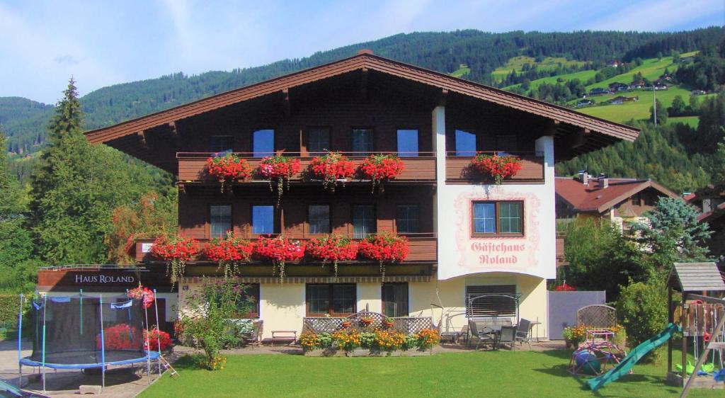 un edificio con cajas de flores en el balcón. en Gästehaus Roland, en Kirchberg in Tirol