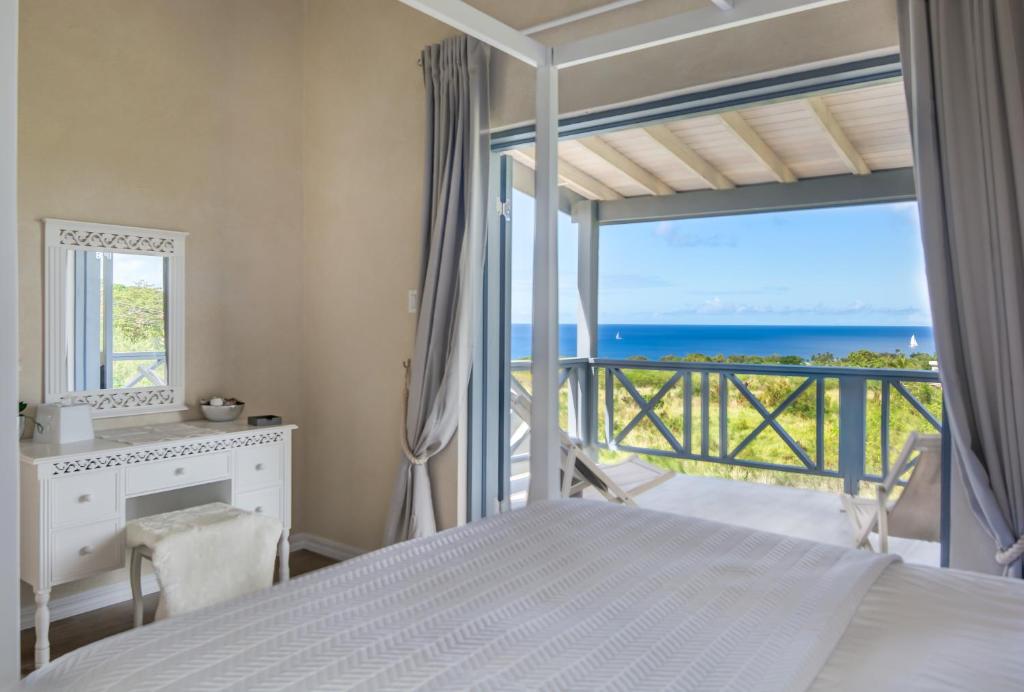 a bedroom with a bed and a view of the ocean at West Rock Villas in Saint James