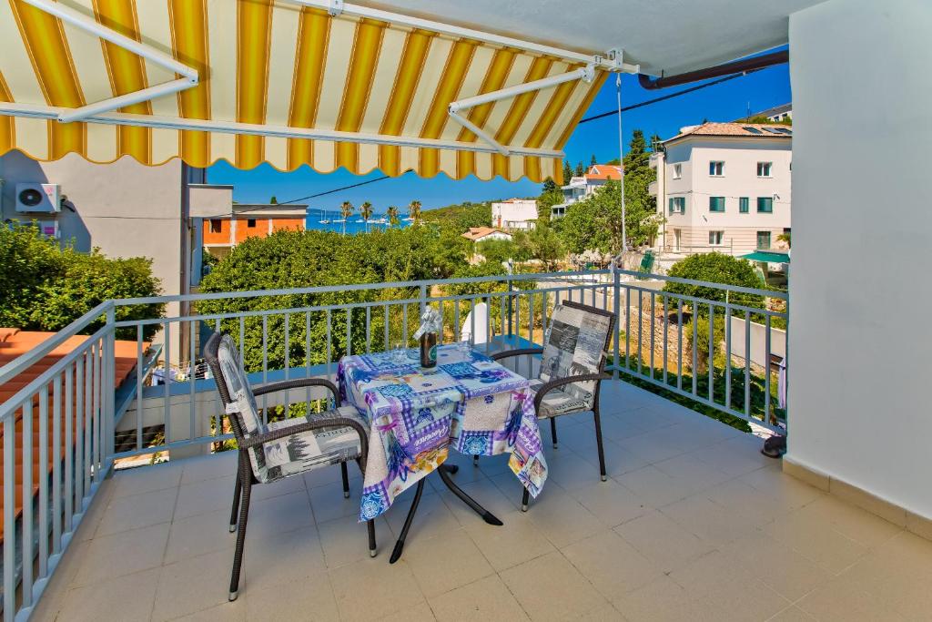 uma mesa e cadeiras numa varanda com um guarda-sol em Apartments Hruban em Hvar