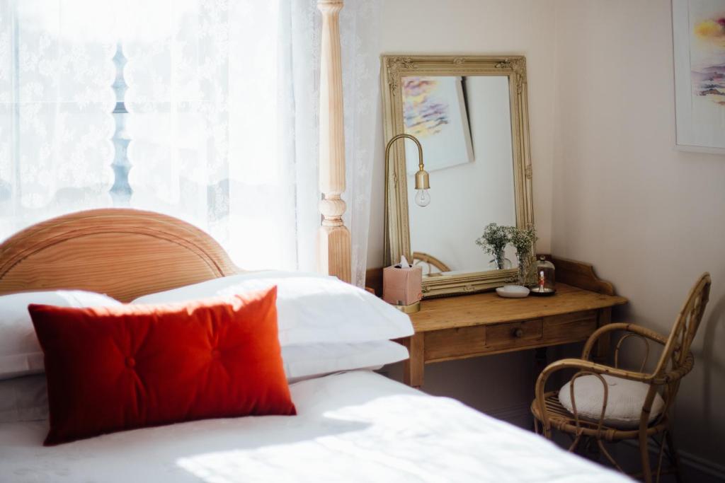 a bedroom with a bed and a mirror and a desk at Tom Blake House in Kells