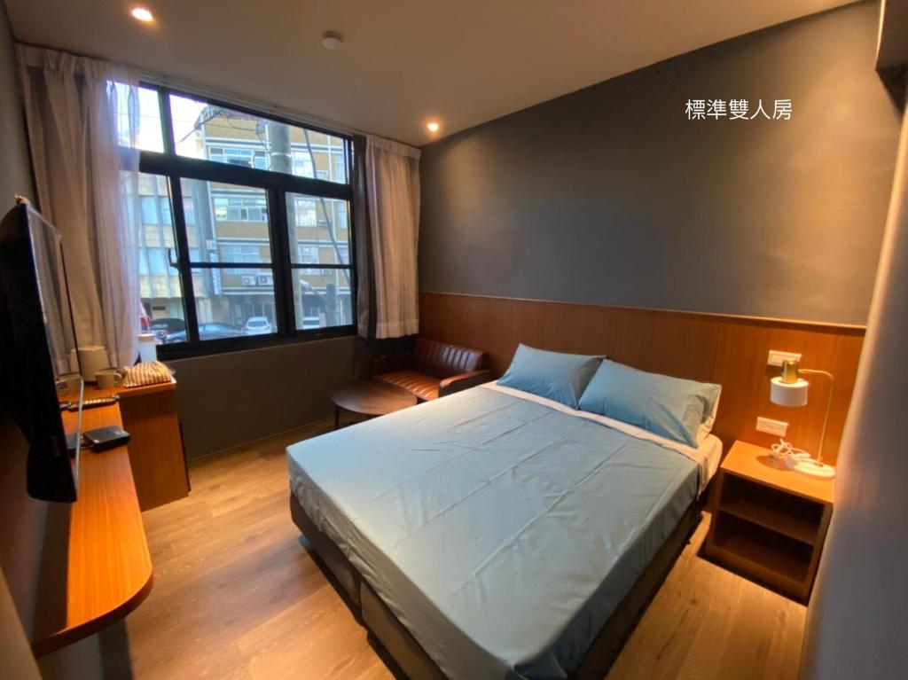 a bedroom with a bed and a large window at 良文旅2館Ryou Hotel Vintage - II in Tainan
