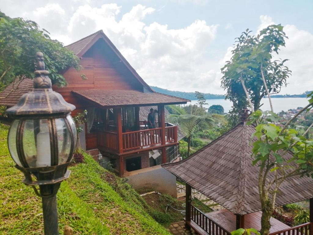 a house on a hill with a balcony and a street light at Flower Hill Villa Bali 'Villa Bukit Berbunga Bali' in Bedugul