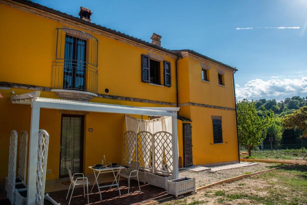 a yellow house with a table and chairs at Le Due Torri in Ancona