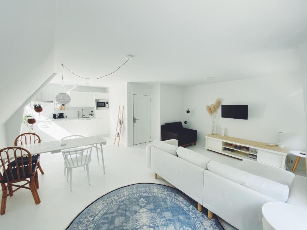 Sala de estar blanca con sofá blanco y mesa en ECHT-Bergen, en Bergen