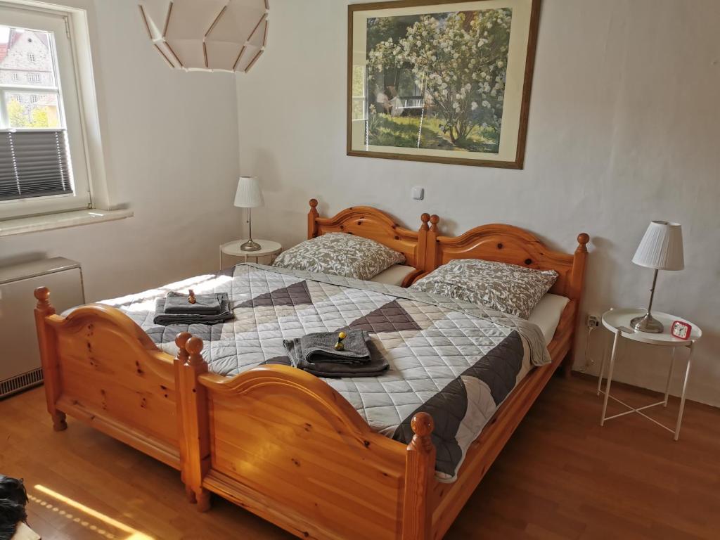 um quarto com uma grande cama de madeira e 2 mesas em Gästehaus Domänenblick em Morschen