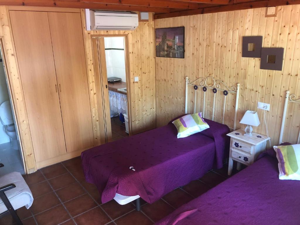 1 dormitorio con cama morada y espejo en Camping Torremolinos, en Torremolinos
