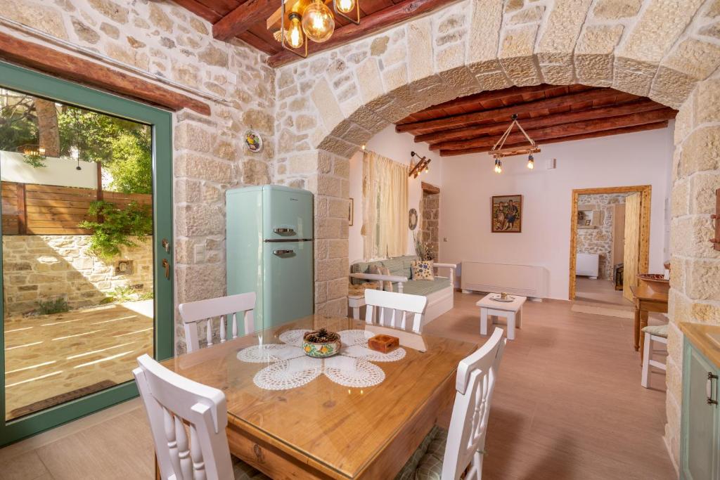Joakim's Villa في بيتسيديا: مطبخ وغرفة طعام مع طاولة وكراسي