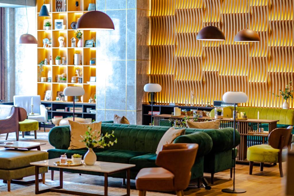 - un hall avec un canapé vert, des tables et des chaises dans l'établissement Hotel Sinaia, à Sinaia