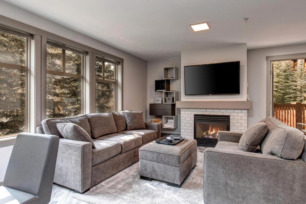 a living room with two couches and a fireplace at Eagle Springs East 206: White Fir Suite in Solitude