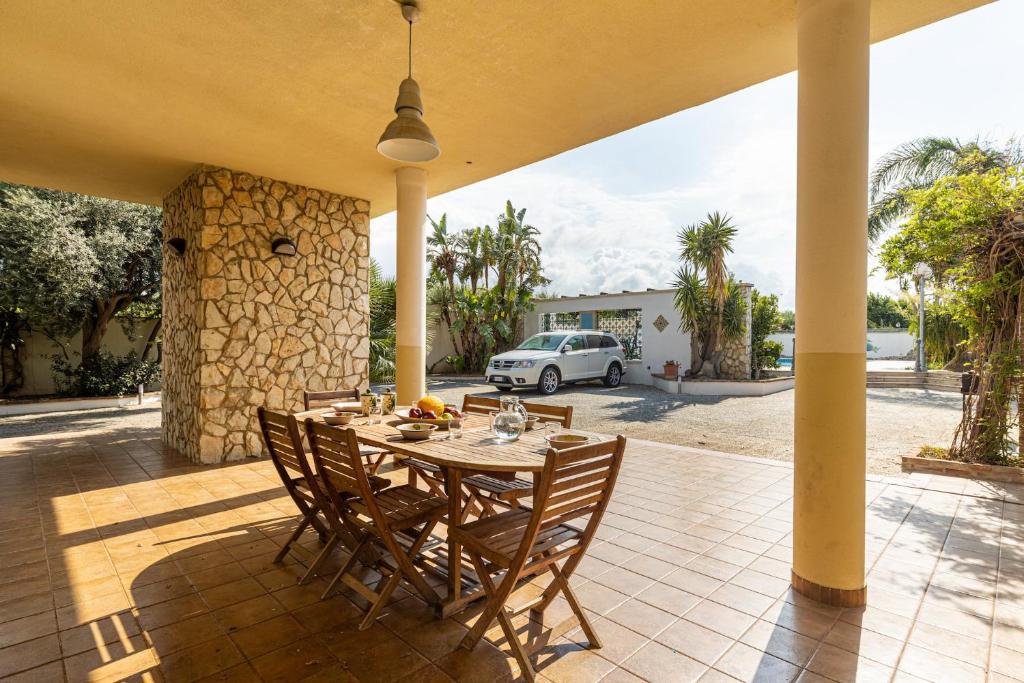 stół i krzesła na patio z samochodem w obiekcie Solemar Sicilia - Villa Anastasia w mieście Ficarazzi