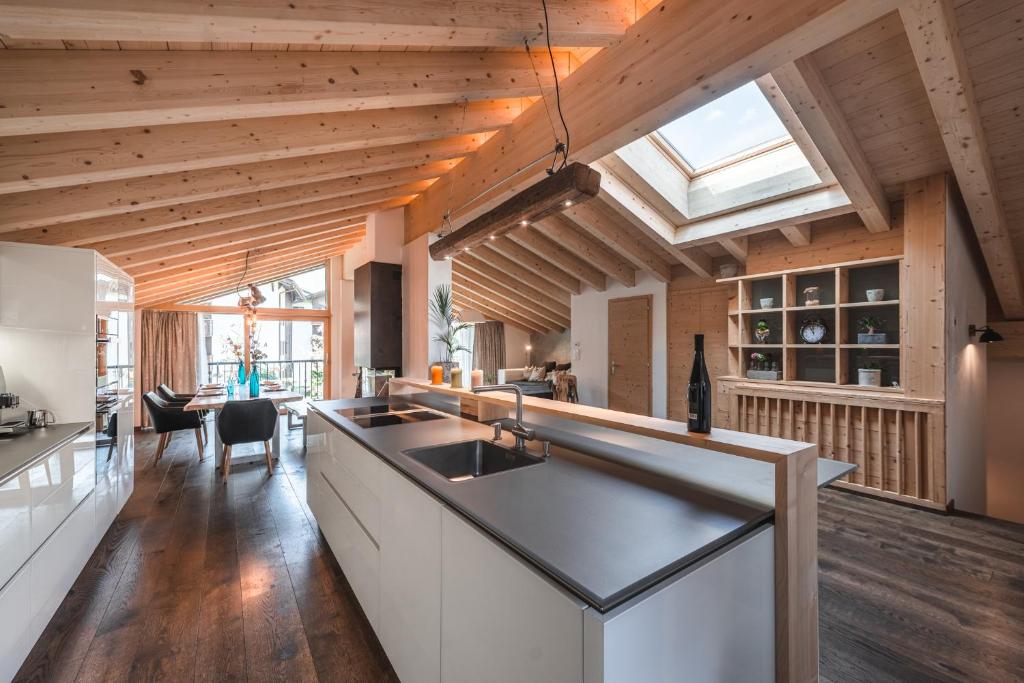 a kitchen with wooden ceilings and a skylight at Joe's Place - luxury lifestyle apartment in Zermatt