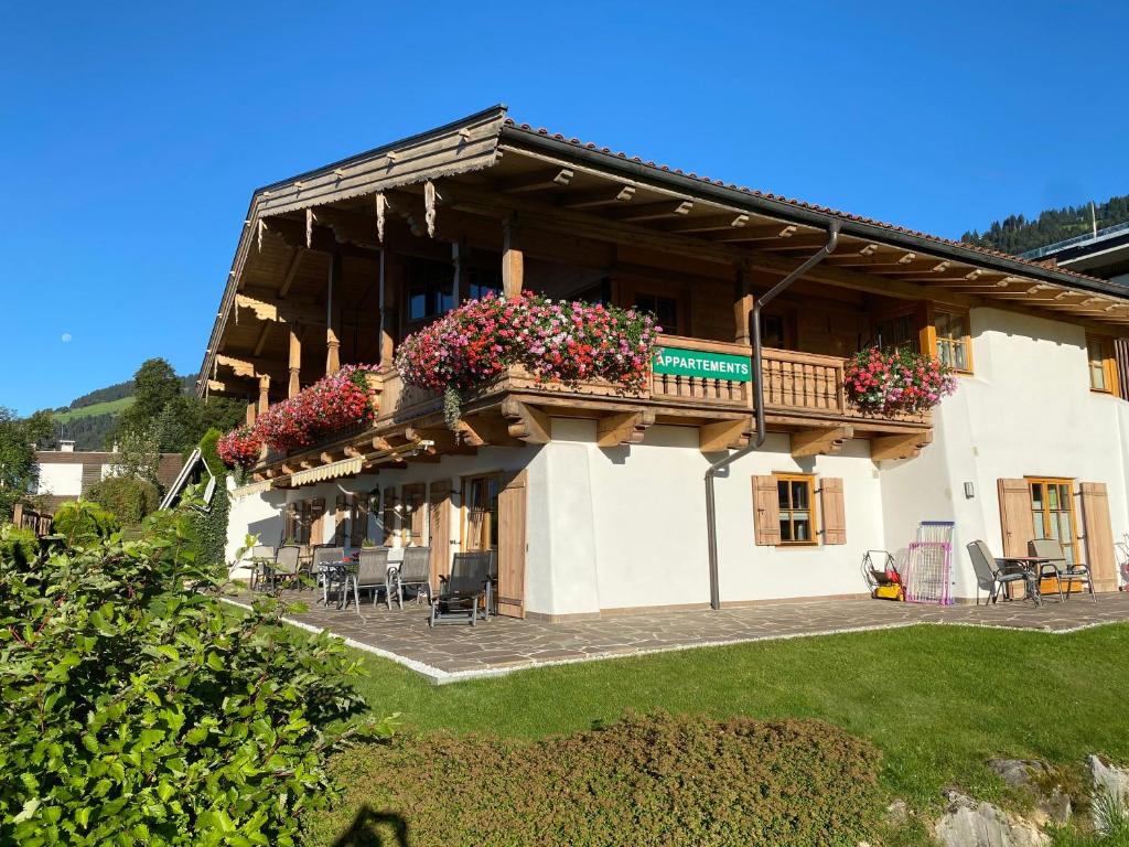 um edifício com uma varanda com flores em Landhaus Krall em Brixen im Thale