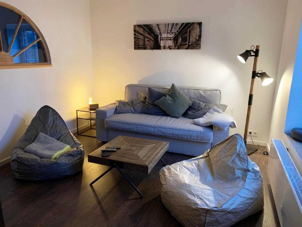 una sala de estar con un sofá y dos sillas en Fehnhaus an der Kuhweide 45236, en Jemgum