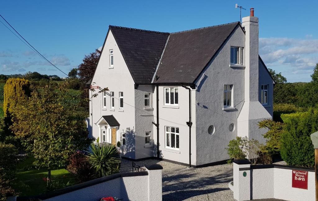 a large white house with a black roof at Wychwood House in Tenby