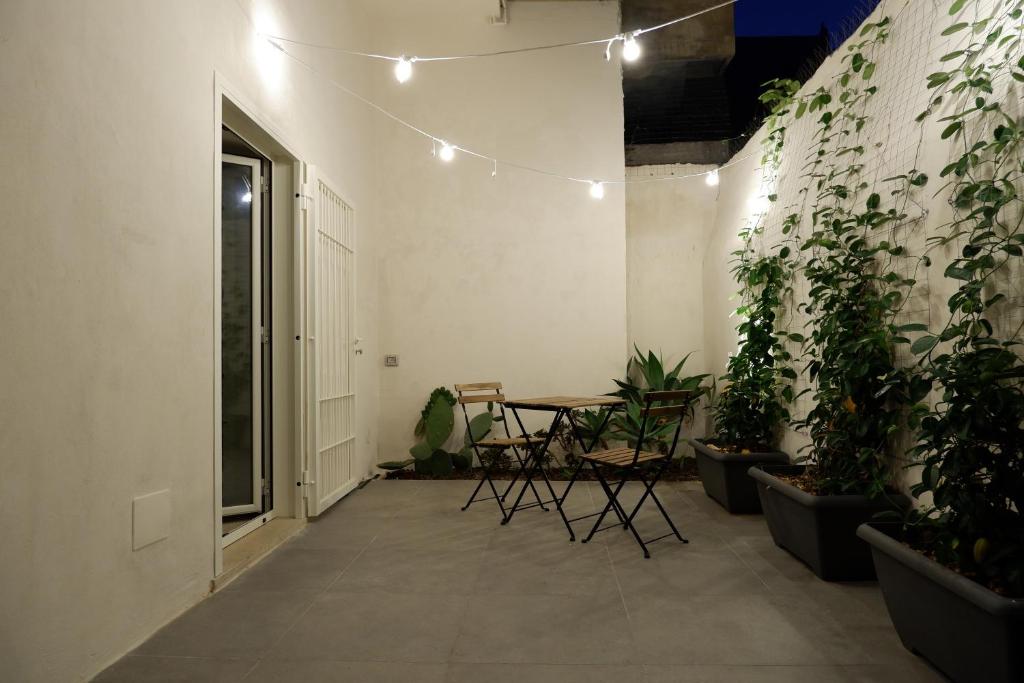 una habitación con una mesa y plantas en la pared en Bari Central Patio, en Bari