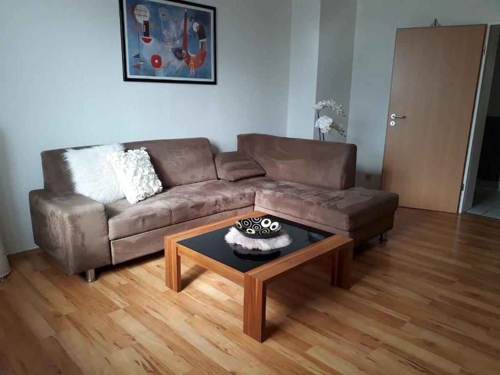 ein Wohnzimmer mit einem braunen Sofa und einem Couchtisch in der Unterkunft Ferienwohnung SimBlick in Simmerath