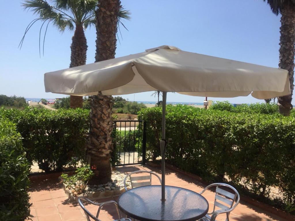 ein Tisch und Stühle unter einem Sonnenschirm auf einer Terrasse in der Unterkunft Casa el Pez in Vera