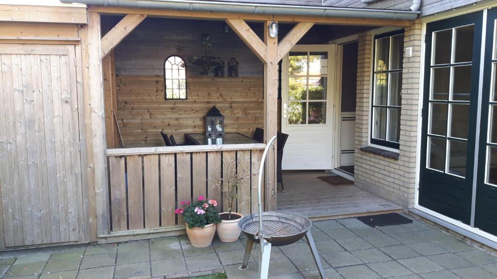 een houten terras met een bar op een huis bij Sneek Vakantiehuis Verhuur in Sneek