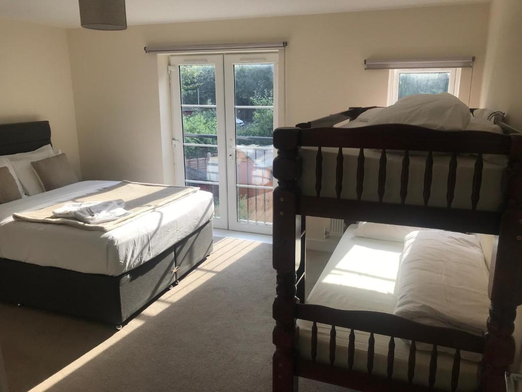 a bedroom with two bunk beds and a window at YBC Court, Aldershot in Aldershot