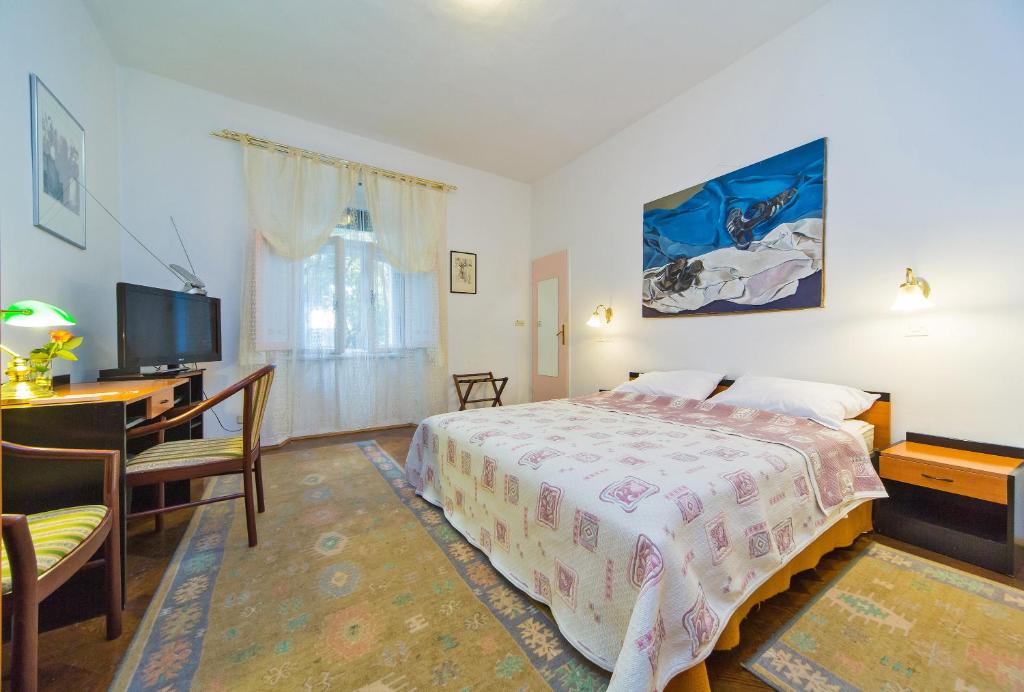 a bedroom with a bed and a desk and a television at B&B Sesame Inn in Dubrovnik