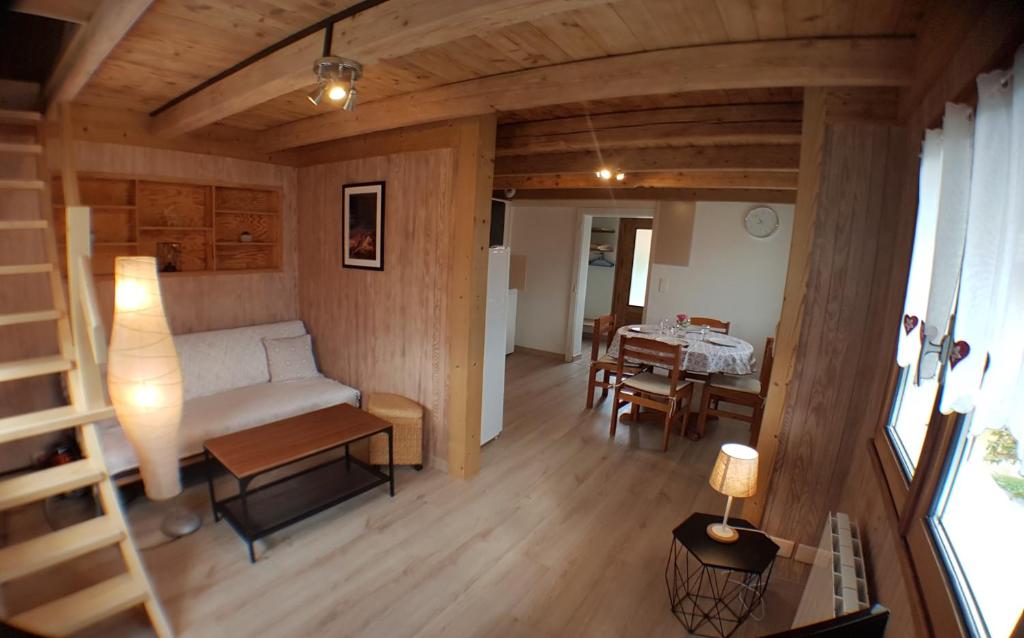 uma sala de estar com um sofá e uma mesa em Chalet avec terrasse et vue sur le Mt-Blanc em Sallanches