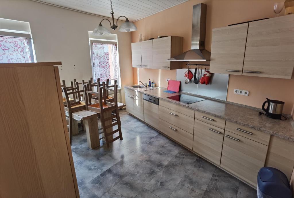 cocina con armarios de madera y comedor en Ferienwohnung Clauss-Theisohn, en Saarbrücken