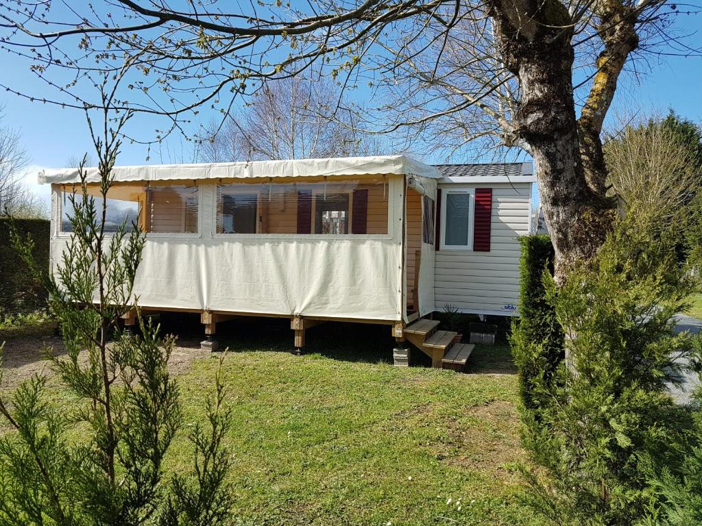 a mobile home with a canopy on a yard at Mobilhome 2ch climatisé à la Palmyre in Les Mathes