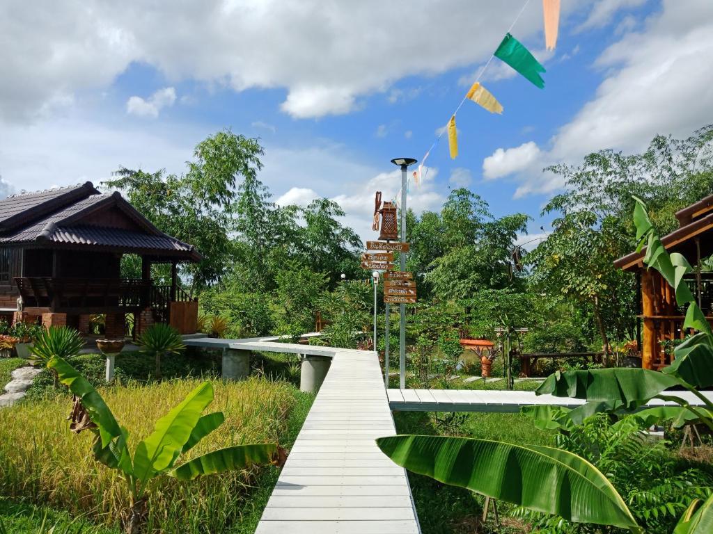 a walkway in the middle of a garden at เรือนไทยใจสุขเอ๋ย in Ban Bang Wa
