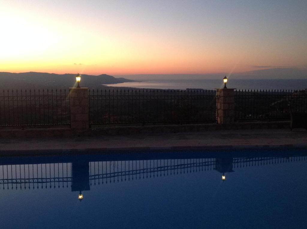 a swimming pool with a sunset in the background at Villa Asteri, views, private, pool heating on request, 30 mins from Paphos in Paphos