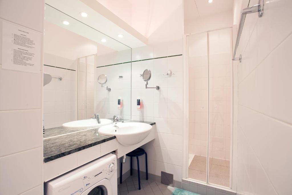 biała łazienka z umywalką i prysznicem w obiekcie GAL Apartments Vienna w Wiedniu