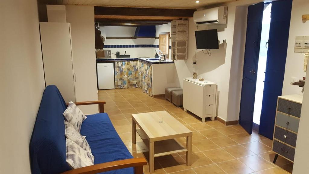 ein Wohnzimmer mit einem blauen Sofa und einem Tisch in der Unterkunft La Casita Azul in Alora
