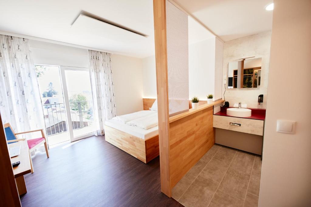 I AM HOTEL Graz-Seiersberg في غراتس: غرفة نوم صغيرة بها سرير وحمام