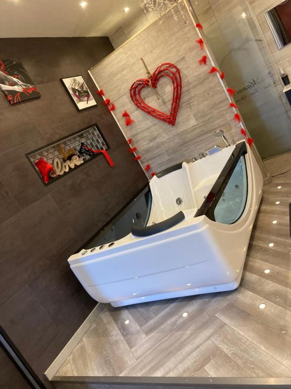 a bath tub in a bathroom with a heart on the floor at MANOIR AUX trois charmes in Ronchamp