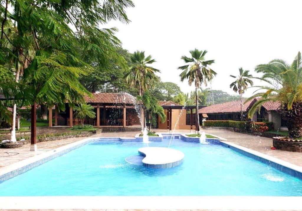 a large swimming pool with a fountain in the middle at Hotel Hacienda Gualiqueme in Choluteca