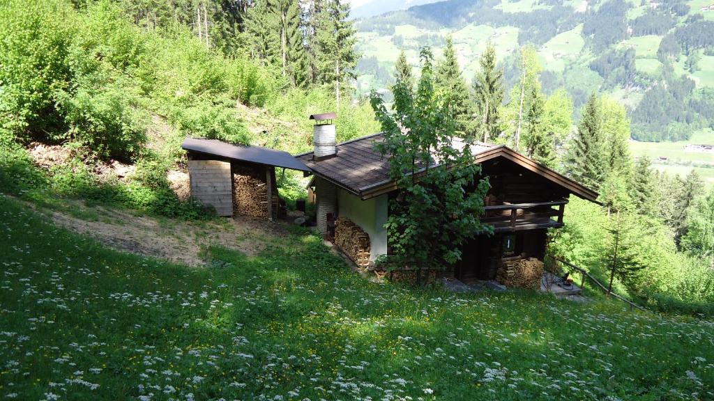una piccola casa su una collina in un campo di Tanterhütte by Tanterhof a Schwendau