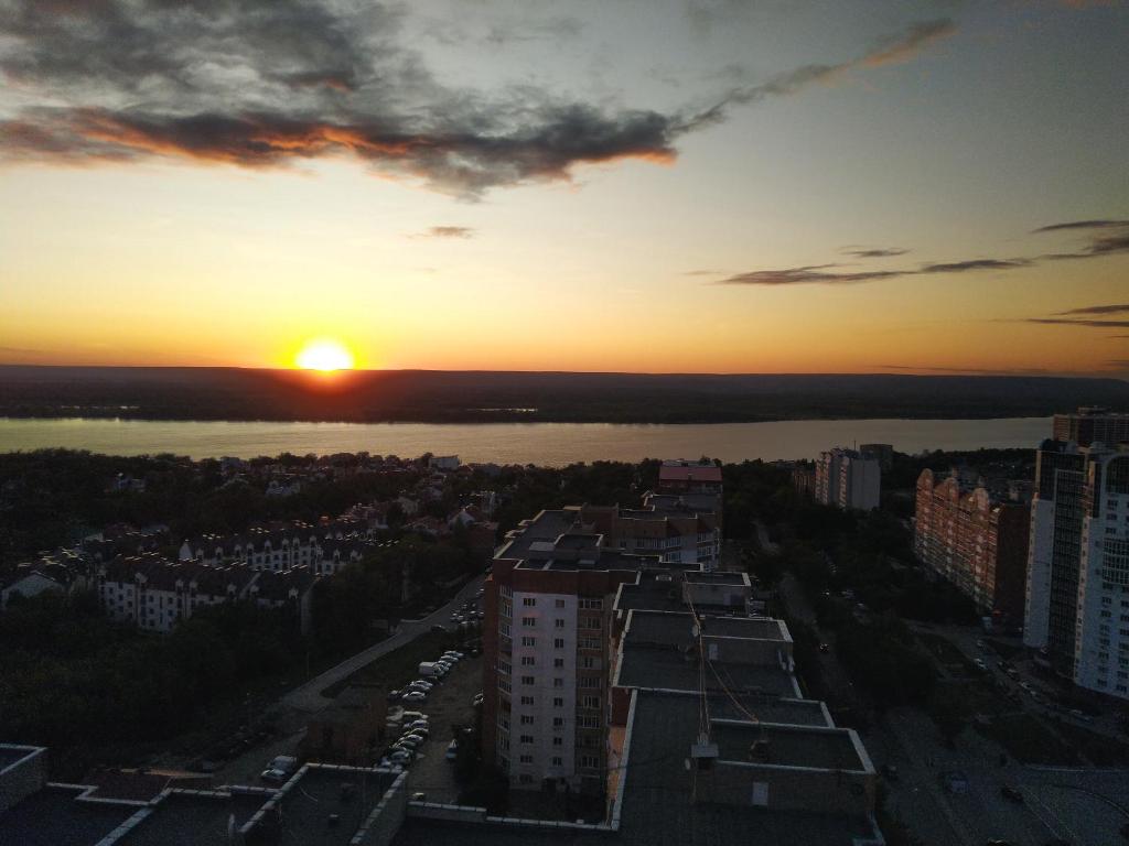 サマラにあるApartments StarHouse на Современникеの川と建物のある街の夕日