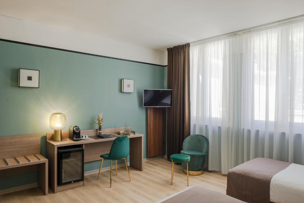 TV a/nebo společenská místnost v ubytování Hôtel Le Bristol