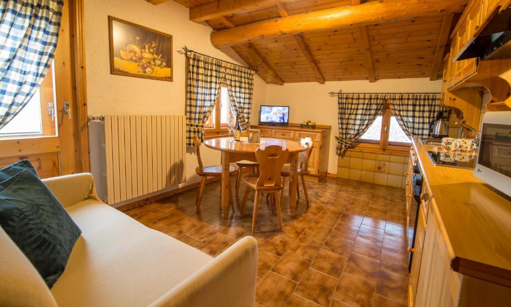 een keuken en eetkamer met een tafel en stoelen bij Appartamento Paola in Livigno