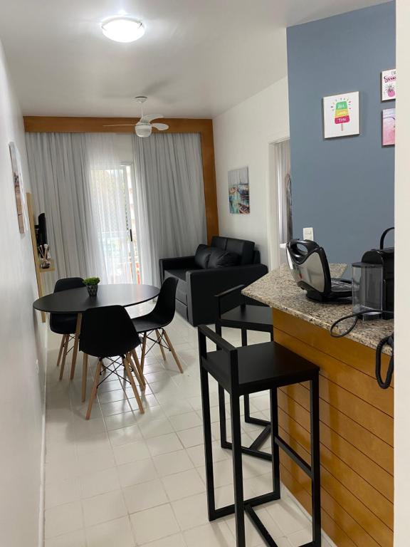 a kitchen and living room with a table and chairs at Flat Boulevard Riviera de São Lourenço - Praia in Riviera de São Lourenço