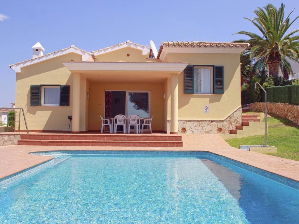 a villa with a swimming pool in front of a house at Casa Llebeig - Sensational Beautiful Property with sea views in Son Bou