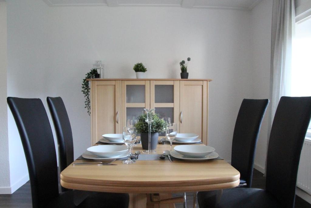 a dining room table with black chairs around it at Haus Sperling in Bad Zwischenahn