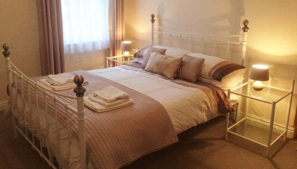 a bedroom with a white bed with two towels on it at Admiral Guest House in Scarborough