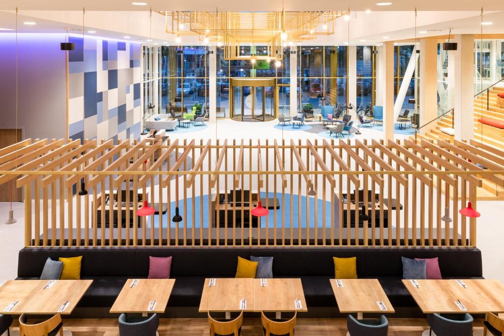 a view of a restaurant with wooden tables and benches at Holiday Inn Express Amsterdam - North Riverside by IHG in Amsterdam