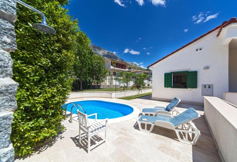 a swimming pool with two lounge chairs and a house at Villa Živana in Dugi Rat