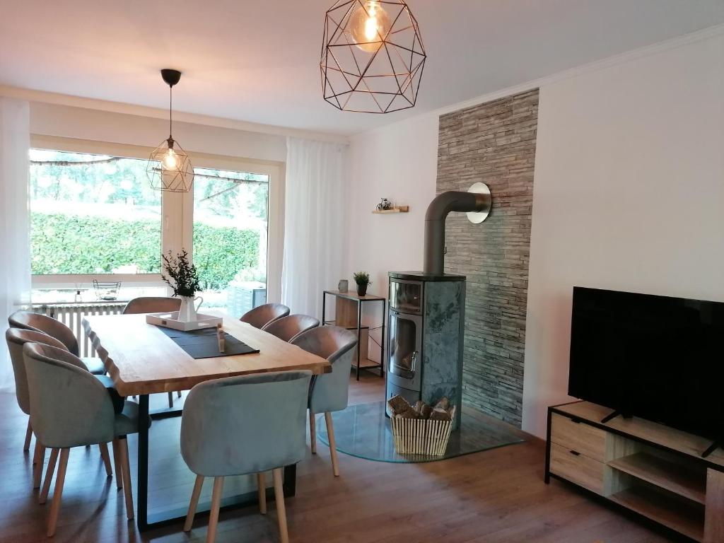 a dining room with a table and a fireplace at Ferienhaus Fasanennest in Uelsen